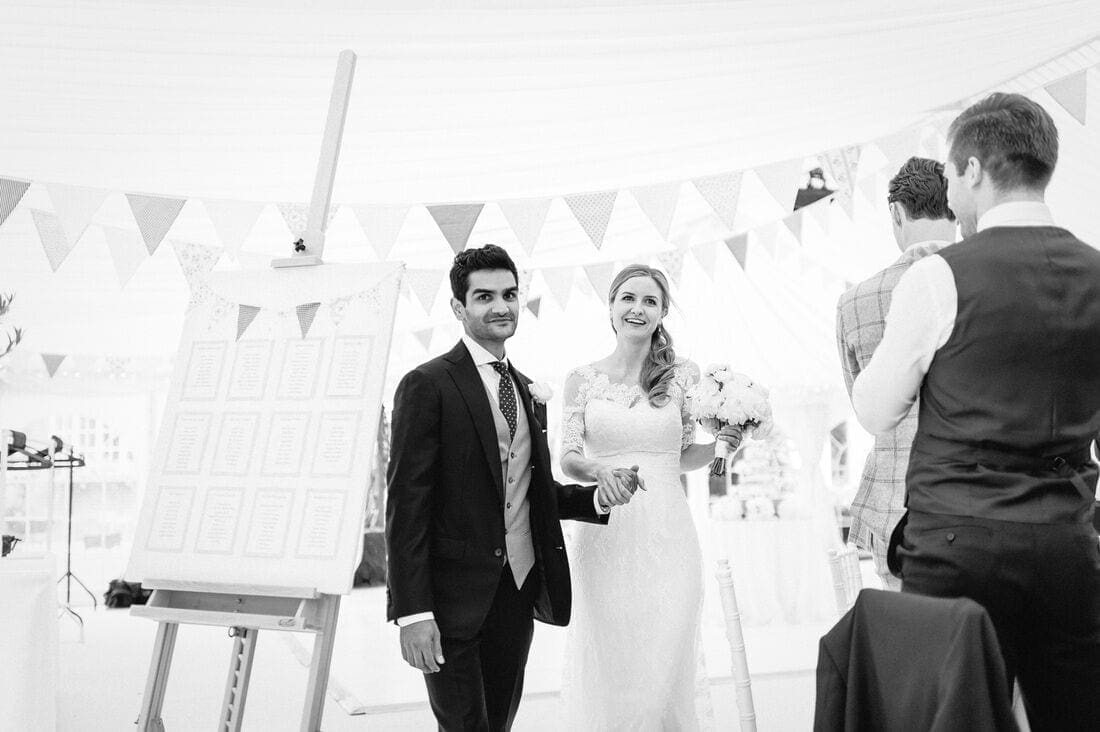 the entrance of the bride and groom to the marquee at their reception in the back garden