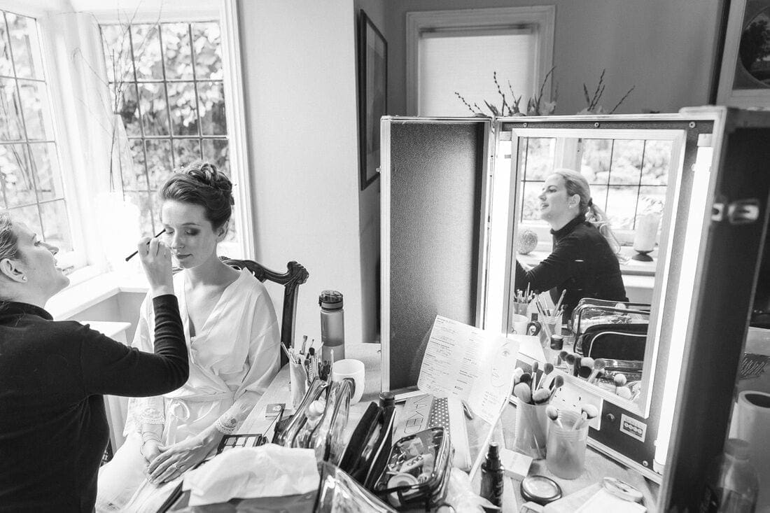 makeup artist getting to work on the bride on the morning of the wedding