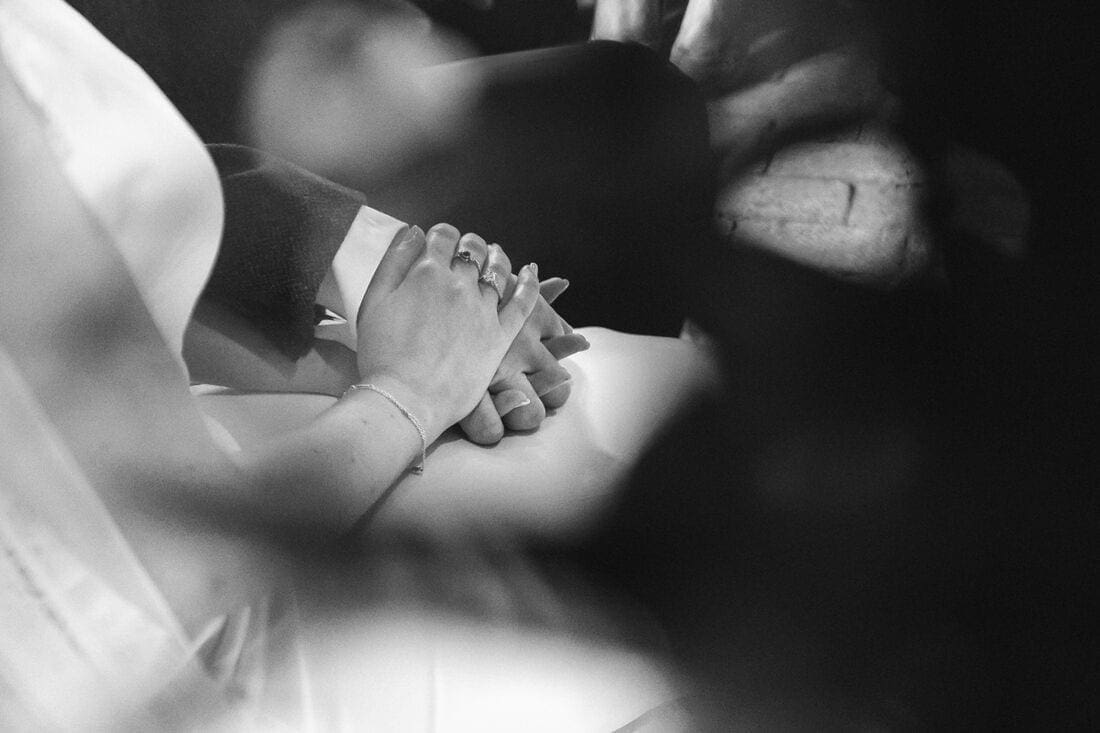bride and groom hold hands during their wedding ceremony