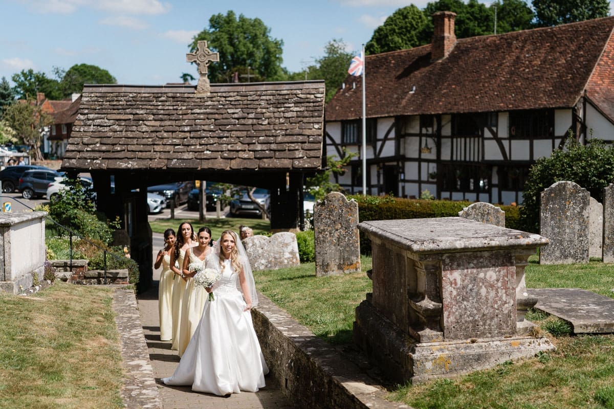 bride and bridesmaids arrive for the wedding ceremony at St Mary's Chiddingfold